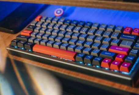 Smart Grids - From above contemporary mechanical keyboard of black and red colors with lightning placed on wooden computer desk